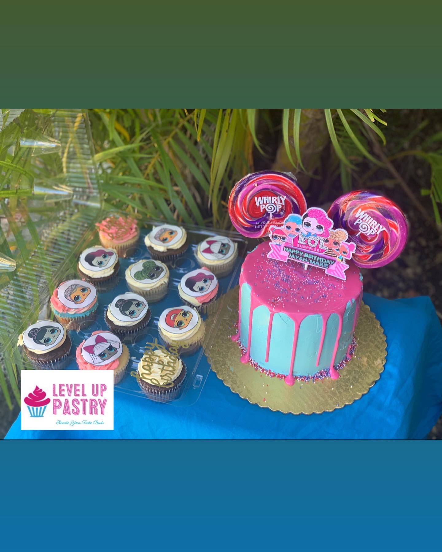 Pink and blue birthday cake with matching cupcakes