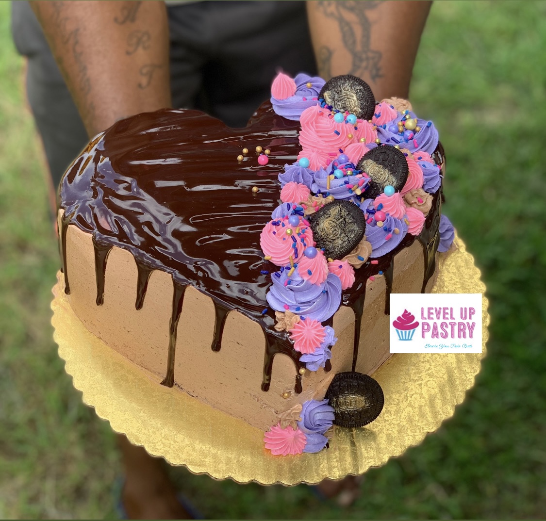 Heart-shaped chocolate cake with pink and purple piping
